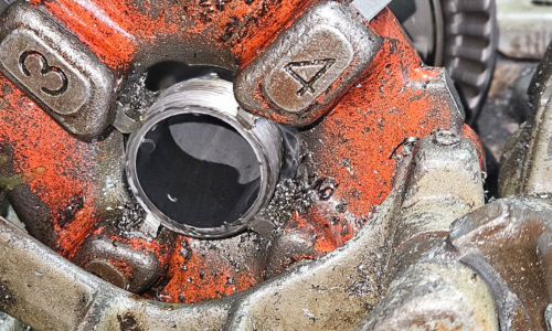 Pipe being threaded by machine